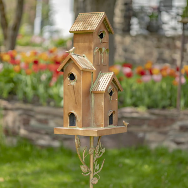 Metal multi-family birdhouse stake in a classic style with short chimney and little bird perched on top of it painted in antique copper finish with patina accents