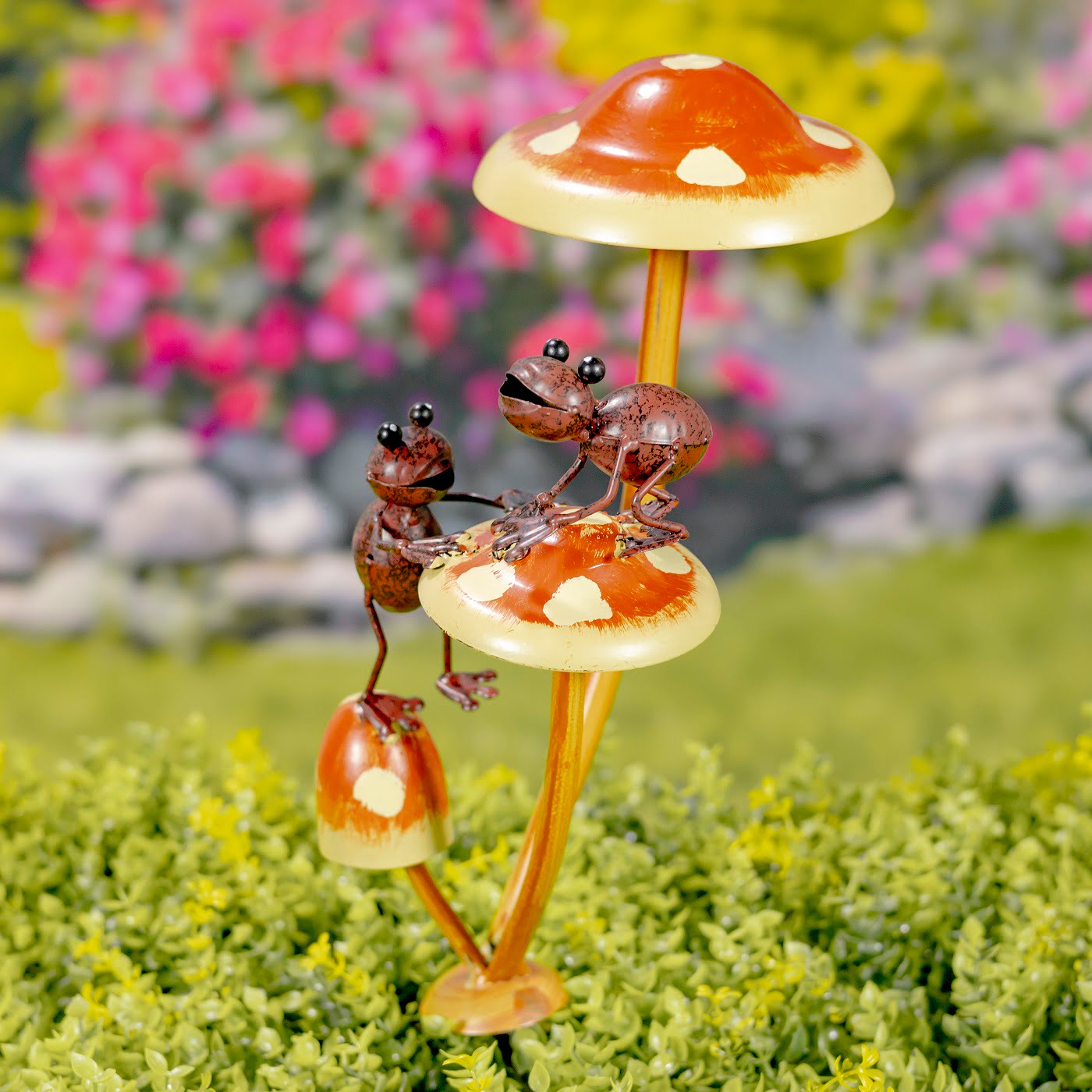 iron garden stake painted in natural colors with 2 friendly frogs helping each other to climb on a mushroom