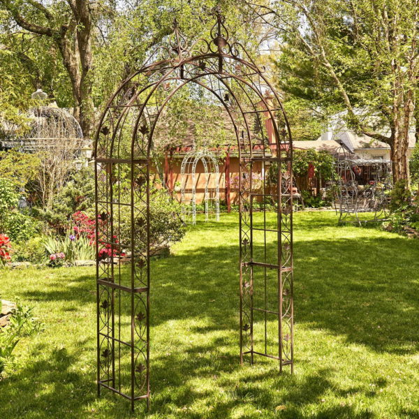 8.5 feet tall iron garden arch with round roof decorated with iron leaves and filigree details in antique bronze distressed finish in garden
