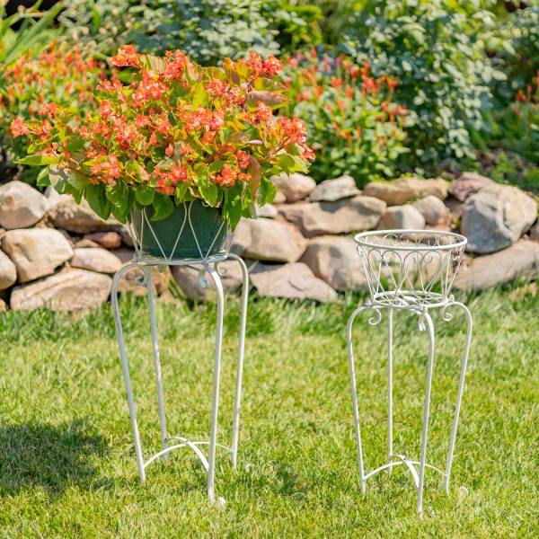 set of 2 ornate standing flower basket plant stands in 2 sizes in antique white finish standing in garden