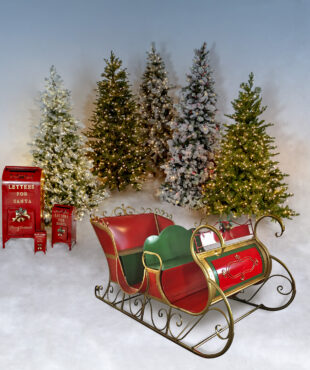 large four person Christmas sleigh with glossy red and hunter green finish and metallic gold trim with ornate design and runners, 3 red mailboxes and 5 Christmas trees on a background