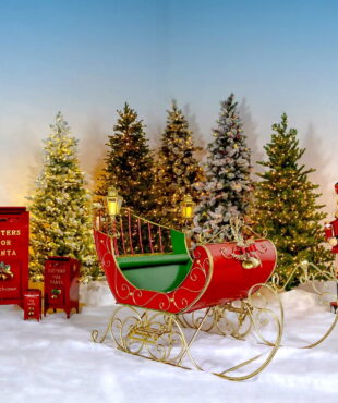 Large Victorian Style Christmas Sleigh Kutaisi in Red, Green and Gold standing next to nutcracker and 3 mailboxes