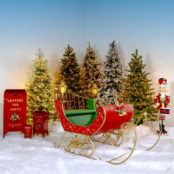 Large Victorian Style Christmas Sleigh Kutaisi in Red, Green and Gold standing next to nutcracker and 3 mailboxes