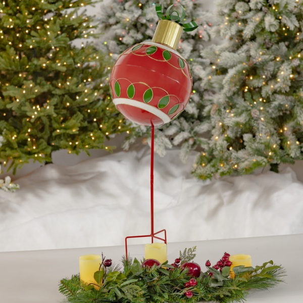 Full View of Metal Christmas Ball Sitting on a Stake in Red