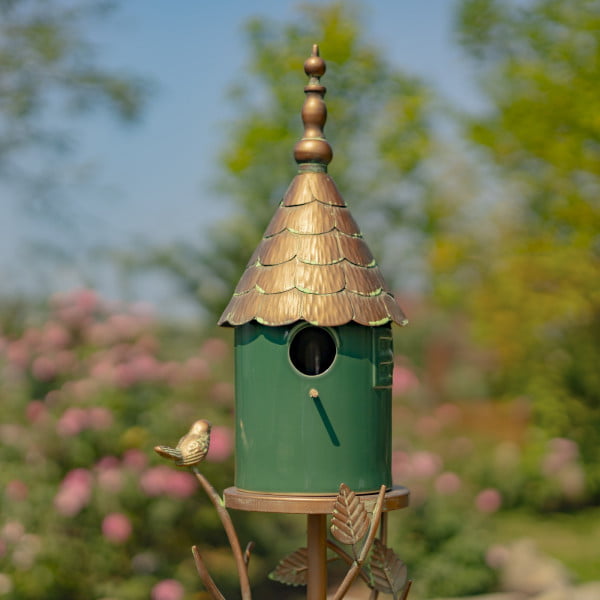 front view image of Iron and dark green porcelain birdhouse stake with cone roof and a little bird perched on leaves attached to the stake