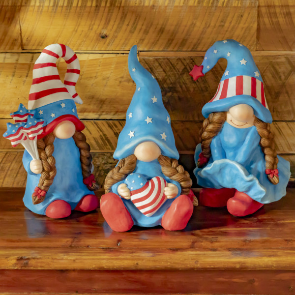 Three assorted American lady patriot garden gnomes with all three of them in the american colors with there two braids flowing down there chest