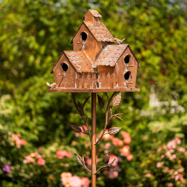 Close up image of New Britain birdhouse stake that has a square frame fence with bird perched at the top of the roof and vines growing from the stake to the birdhouse