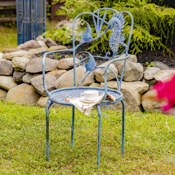 Coastal armchair with with sea lion and fishes designed on the backrest of the chair with little teacup and saucer placed on it for additional décor (Tea cup and saucer not included )