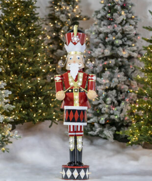 Tall large iron Christmas Nutcracker dressed professionally in his Christmas colors with his drum stocks in hands and his drum attached to his waist