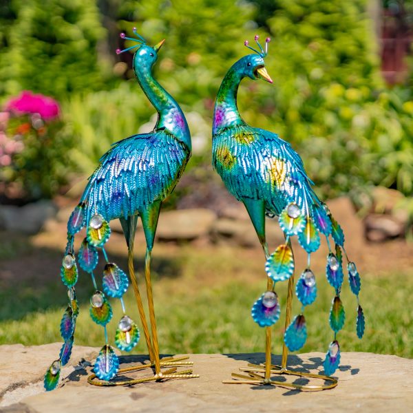 pair of 2 metallic painted iron peacock garden figurines with gems in garden