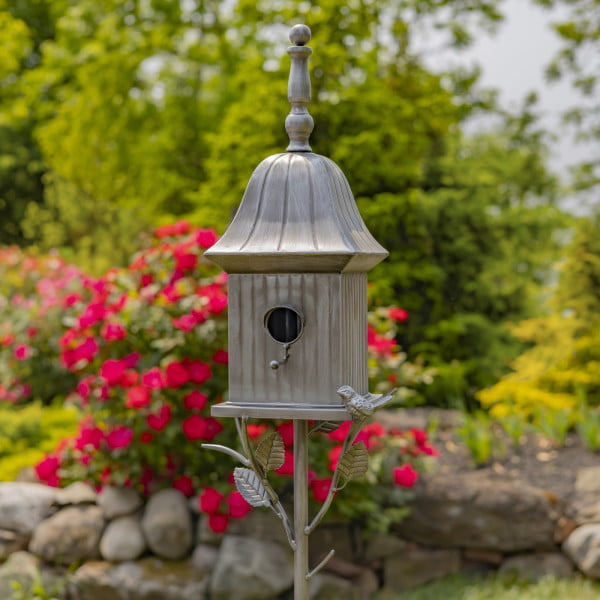 closed up image of iron cone roof birdhouse stake in antique silver hand-painted finish with little bird perched on decorative leaf