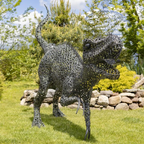 front view of 7.3feet tall crouching Tyrannosaurus Rex metal sculpture with filigree details in metallic black-bronze distressed finish