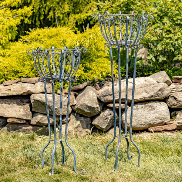 Set of 2 tall iron basket plant four-legged stands with heart-shaped details in distressed antique blue finish in garden