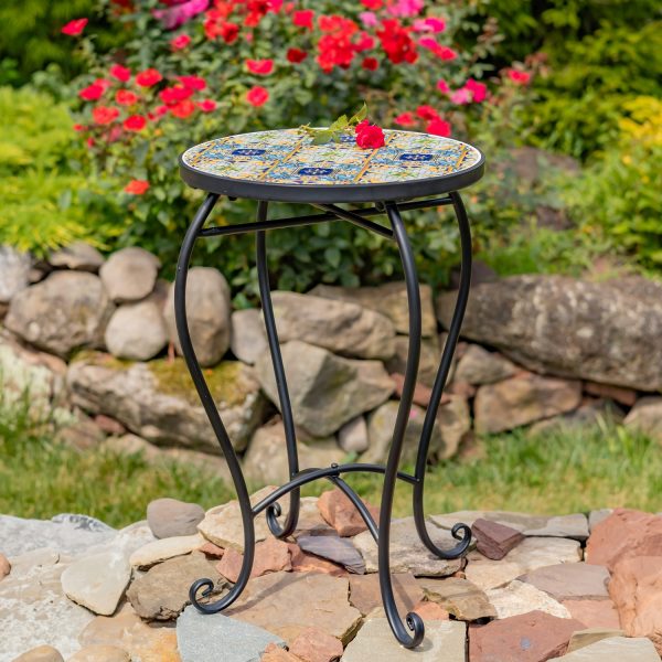 Bar Harbor Pedestal Plant Stand features a round top with checkerboard design and floral accents, attached to a sturdy matte black metal frame.