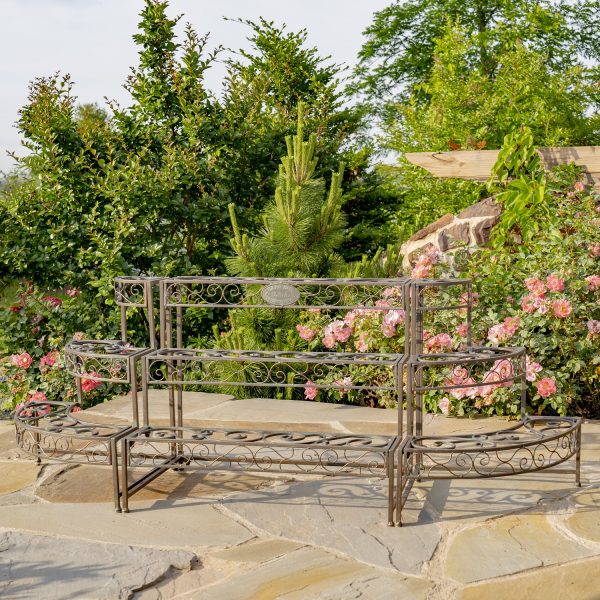 Three Tier Metal Riser Plant Stand in antique bronze on a stone patio