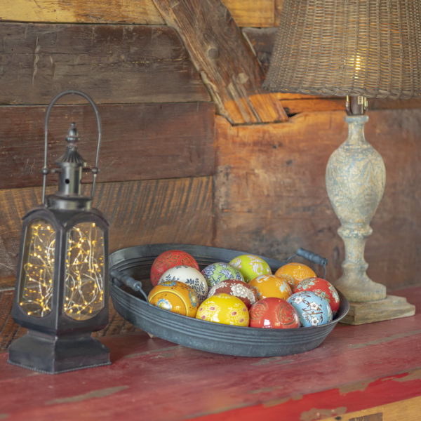 Ceramic Balls sitting in a Pant on a table in assorted colors and designs