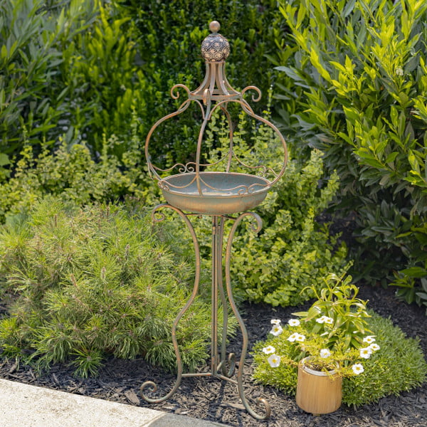 Tall standing bronze iron birdbath with brown ceramic floral designed ball with curlicue folding legs