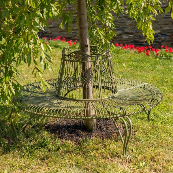 Victorian style round curved metal tree bench encircling the trunk of a tree in antique green distressed finish