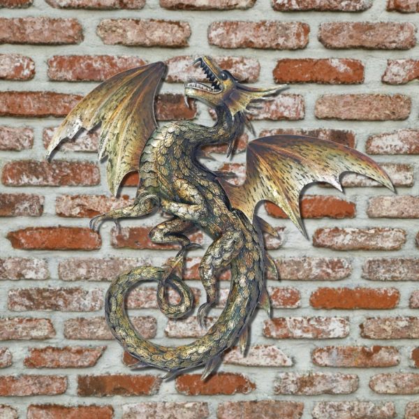 Metal dragon wall decor with metallic gold and balck color against a brick wall