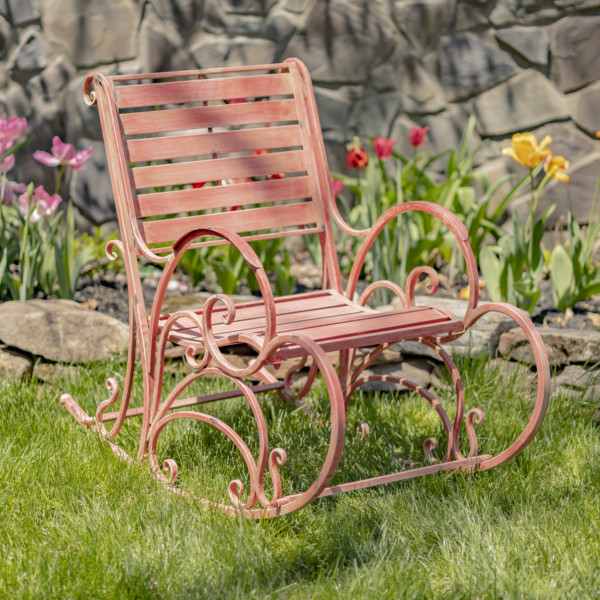 Side image of Flamingo Pink iron rocking arm chair with curlicue dedigns on the side