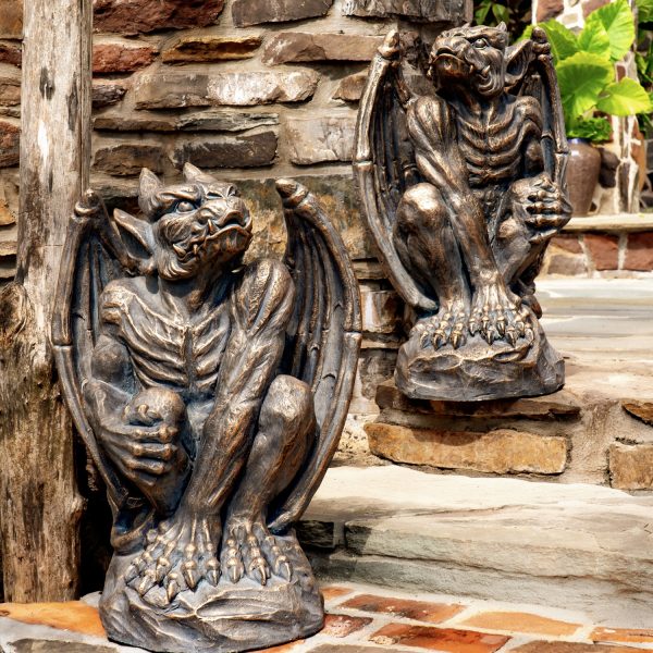 Two gargoyles in antique bronze, showing the front with their arms and legs