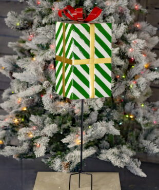 37 inch tall metal green and white striped Christmas gift box stake with red metal ribbon on top of it