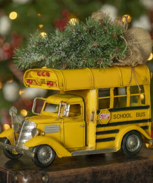 side view image of metal vintage style small school bus with Christmas tree on top of it