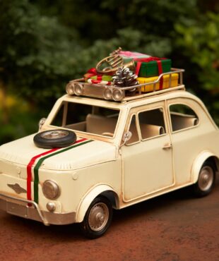 1980 Vintage Creamy Colored Car with a spare tire on the hood and Christmas Gifts on the roof of the car tabletop decor