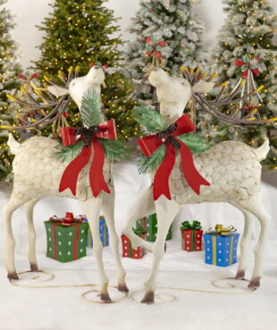 Two large white iron reindeer with pinecone bow watching upwards standing on a curlicue iron design