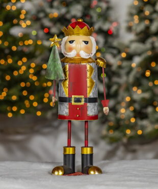 galvanized metal Christmas nutcracker figurine wearing crown and holding Christmas tree