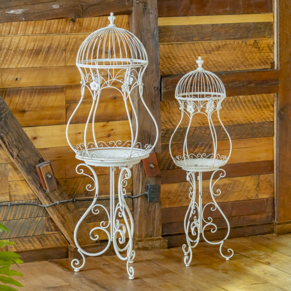 Two Metal Plant Stands shaped like an hour glass birdcage in Antique white with curlicue structure folding stands