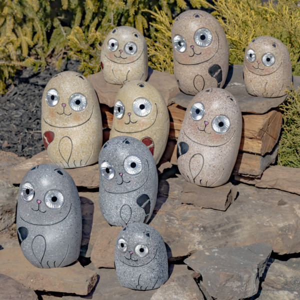 One set of nine Solar Rock Cats sitting on some rocks in Cream Grey and Peru looking at you with there large round eyes that lights up in the dark