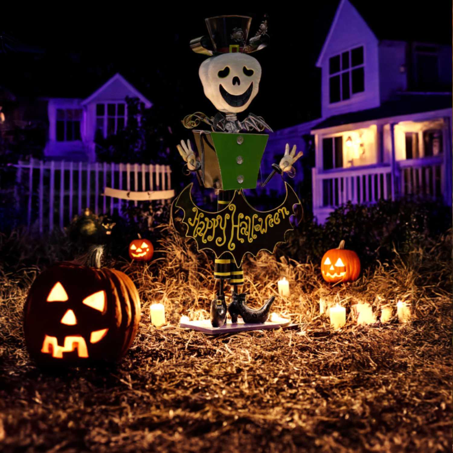 tall iron Halloween skeleton figurine in top hat holding Happy Halloween sign in fall forest surrounded by light up pumpkins and house in purple