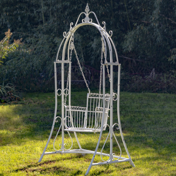 Large white iron swing chair with curlicue designs to the top of the swing and a neatly deigned chair with four iron chains holding it up