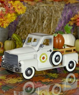 side view of 18 inch long antique white metal pickup truck tabletop decor with pumpkins