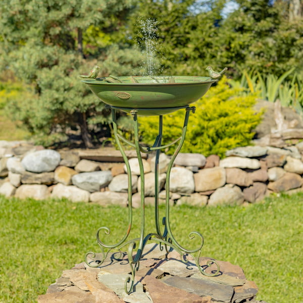 full length image of 31 inch tall iron birdbath with two bird sculpture details perched on basin edge, decorative stand with a distressed hand painted verdi green finish outdoors