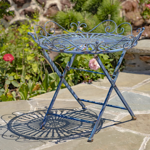 Victorian-style wrought iron folding garden table with X-shaped legs and filigree details in antique blue distressed finish in garden