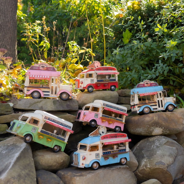 6 vintage style ice cream and coffee trucks in assorted styles and colors on rocks in garden