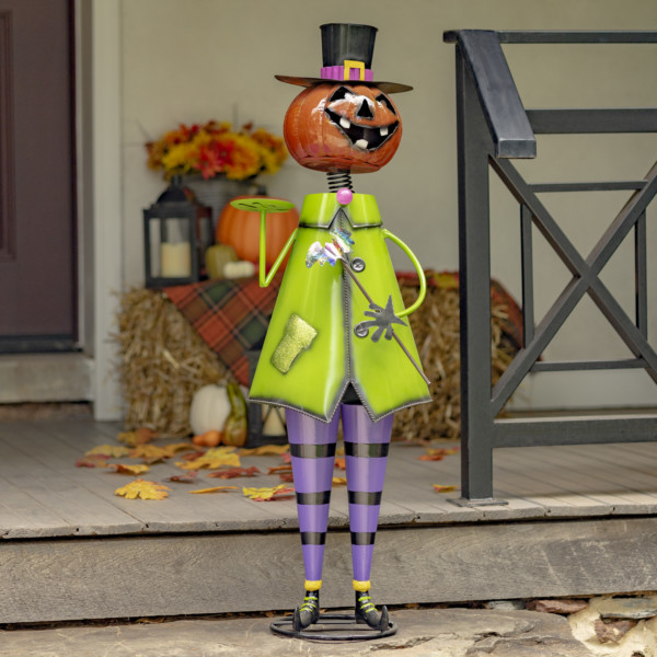 Halloween decoration of a short iron pumpkin man holding up a small tray in his hand wearing his green jacket and purple pants smiling