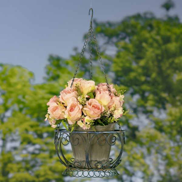 iron round hanging basket decorated with twirls in distressed cobalt blue finish with cream and pink roses in it
