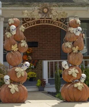 9.6 feet tall large iron Halloween arch with orange pumpkins, white skulls with purple LED lights, golden leaves and Happy Halloween sign in front of house entrance