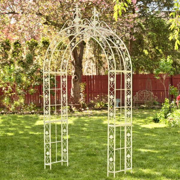 8.5 feet tall iron garden arch with round roof decorated with iron leaves and filigree details in antique white distressed finish in garden