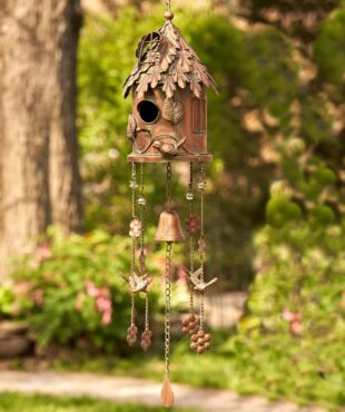 full length image of metal hanging on a chain cylinder shaped birdhouse with wind chimes in antique copper finish