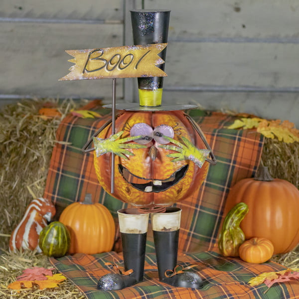 Jack-o-Lantern pumpkin Halloween figurine in top hat and boots holding Boo sign on fall background