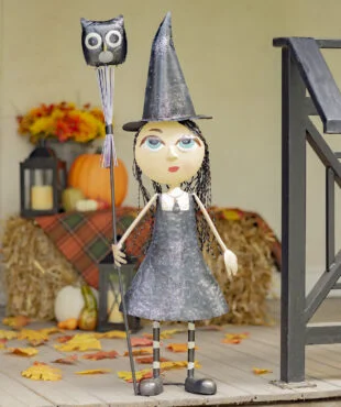 Halloween decoration of Tall Metal Big eye witch girl wearing a black dress and pointed hat holding a stake