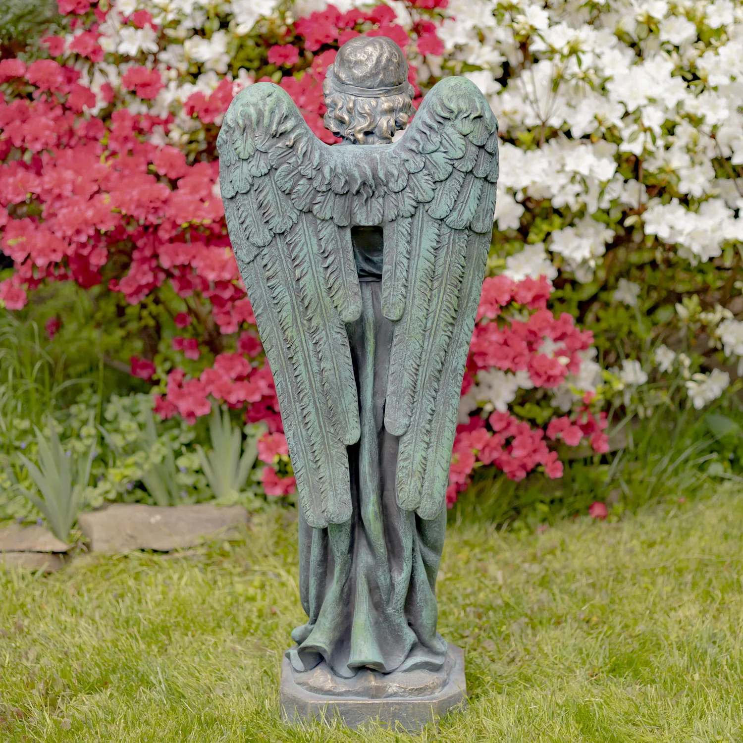 wings of 47 inch tall magnesium angel statue painted in antique bronze finish in garden