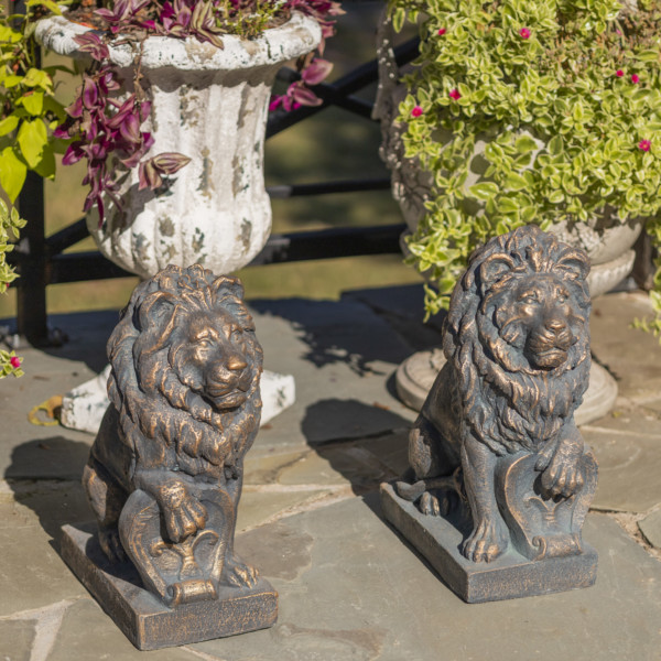 Two magnesium Lion statue in antique bronze sitting upright with one of there paw cocked on a shield