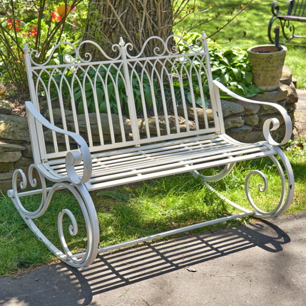 Iron rocking bench with filigree armrest and bottom part in antique white finish in garden