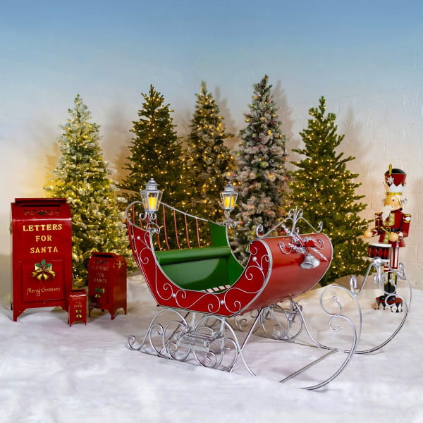 Large Victorian Style Christmas Sleigh Kutaisi in Red, Green and Gold standing next to nutcracker and 3 mailboxes