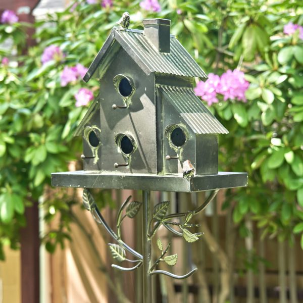 galvanized metal multi-family birdhouse stake in a classic style with short chimney and little bird perched on top of it with patina accents